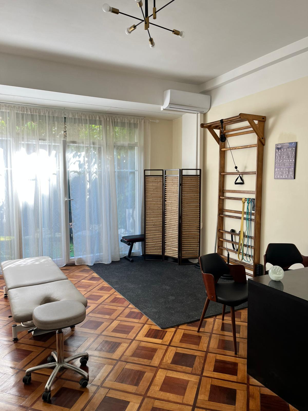 Salle de soins du cabinet d’ostéopathie à Nice, avec espalier et matériel de renforcement
